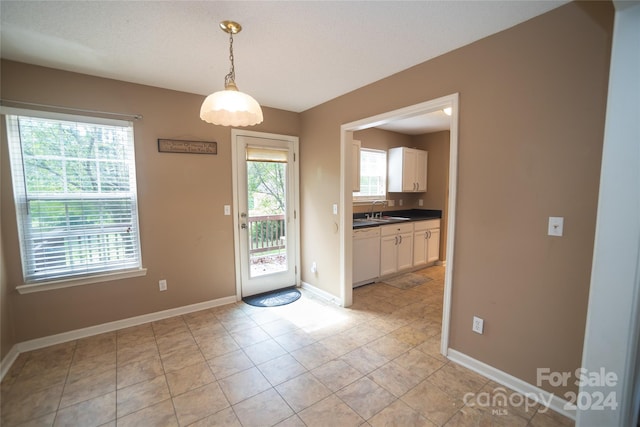 unfurnished dining area with sink and light tile patterned flooring