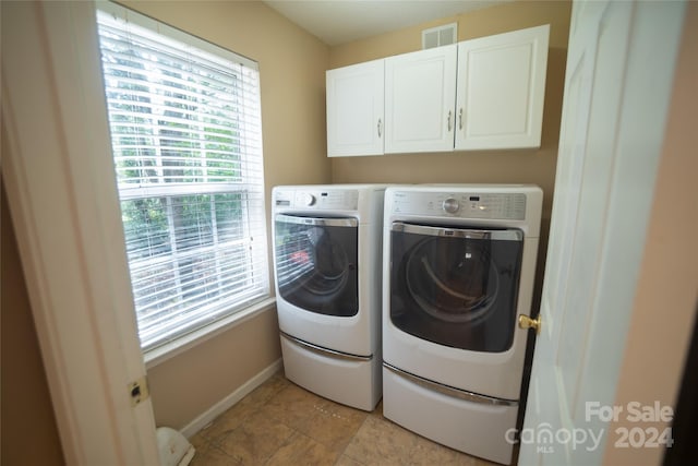 washroom with cabinets and washer and dryer