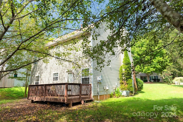 back of property featuring a yard and a wooden deck