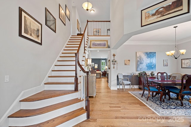 entrance foyer featuring a chandelier, light hardwood / wood-style flooring, and crown molding