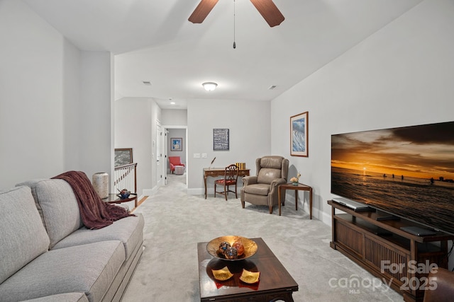 living area with light carpet, a ceiling fan, visible vents, and baseboards