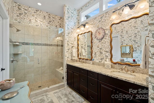 bathroom with double vanity, a stall shower, a sink, and tile patterned floors