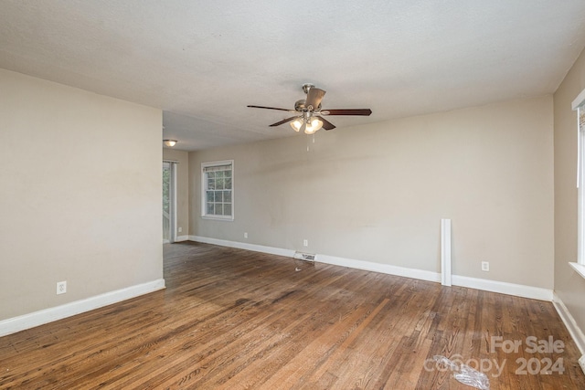 empty room with visible vents, ceiling fan, baseboards, and wood finished floors