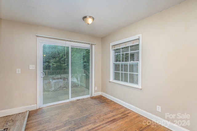 spare room featuring baseboards and wood finished floors