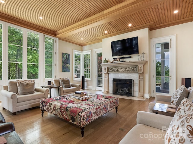 living room with a tile fireplace, a healthy amount of sunlight, and hardwood / wood-style floors