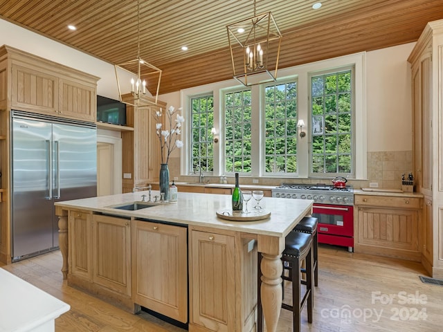 kitchen featuring light hardwood / wood-style floors, high end appliances, a center island with sink, and wooden ceiling