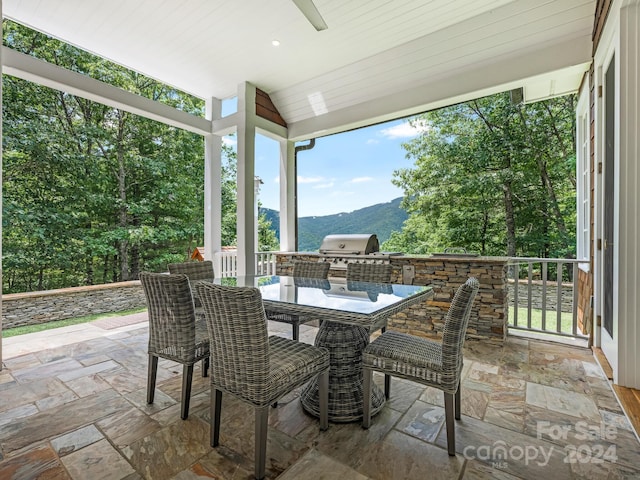 view of patio / terrace with a mountain view, an outdoor kitchen, and grilling area