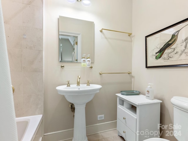 bathroom featuring tiled shower / bath combo, tile patterned floors, and toilet