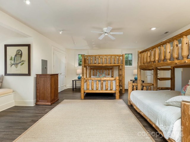 bedroom featuring multiple windows, electric panel, ceiling fan, and dark wood-type flooring