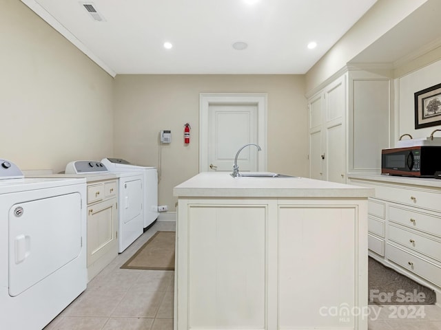 washroom with washing machine and clothes dryer, sink, and light tile patterned floors