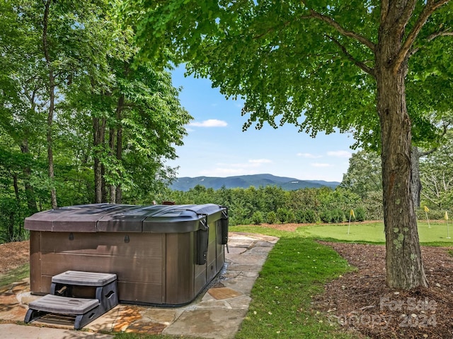 view of yard with a mountain view and a hot tub