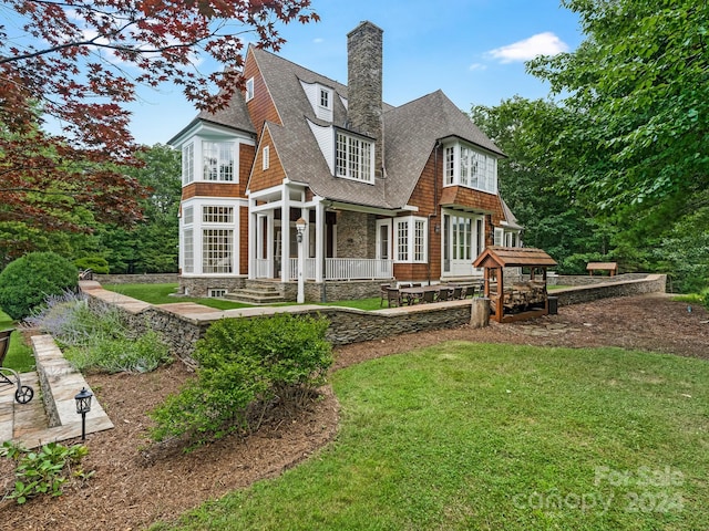 rear view of house with a wooden deck and a yard