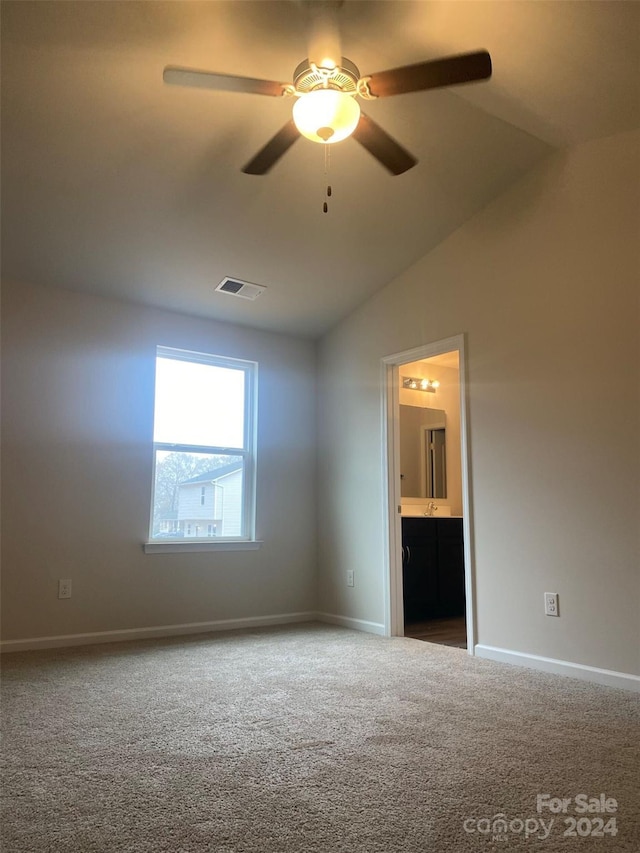 carpeted empty room featuring ceiling fan and vaulted ceiling