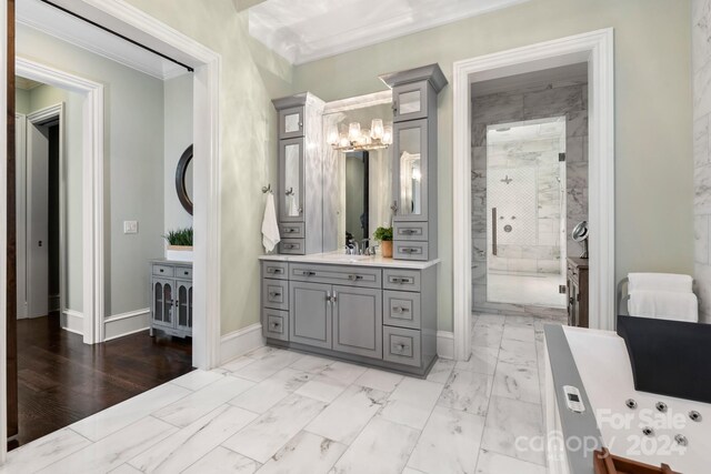 bathroom with an inviting chandelier, a tile shower, tile patterned floors, vanity, and ornamental molding