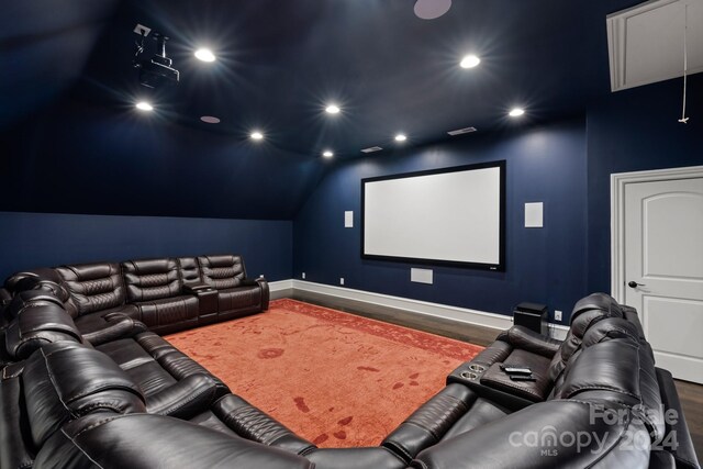 home theater room featuring vaulted ceiling and hardwood / wood-style floors