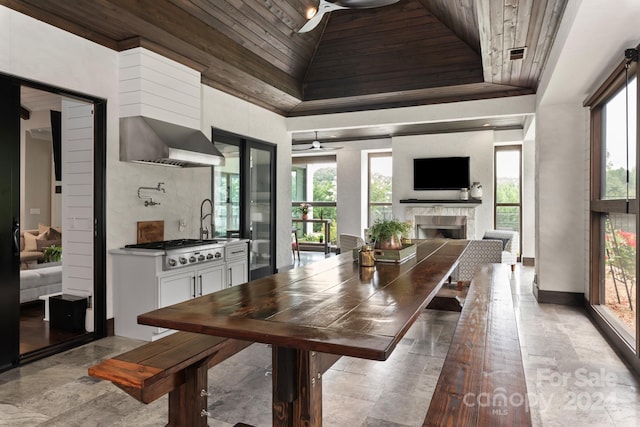 tiled dining space featuring sink, ceiling fan, and wood ceiling