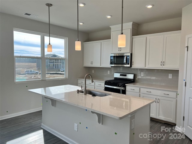 kitchen featuring appliances with stainless steel finishes, white cabinets, sink, backsplash, and dark wood-type flooring