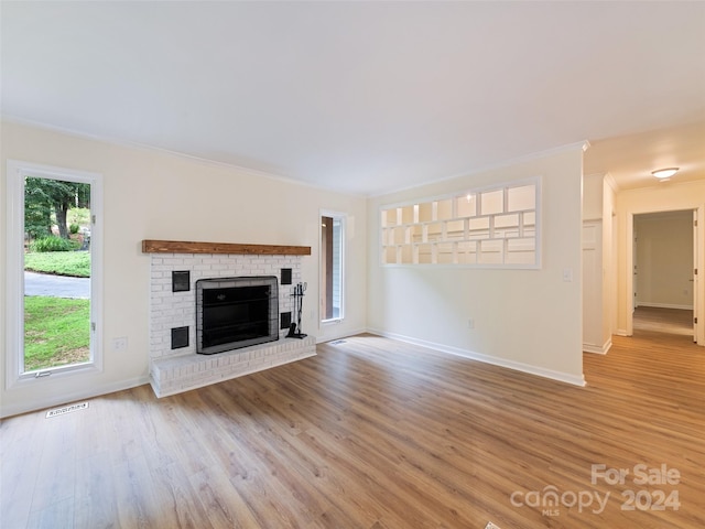 unfurnished living room with a fireplace, ornamental molding, and light hardwood / wood-style floors