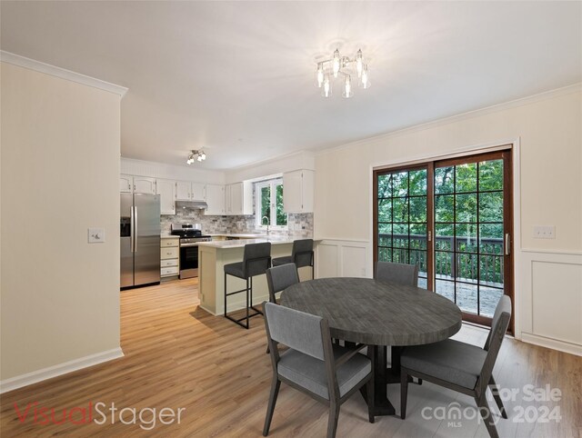 dining area featuring light hardwood / wood-style flooring, sink, and plenty of natural light