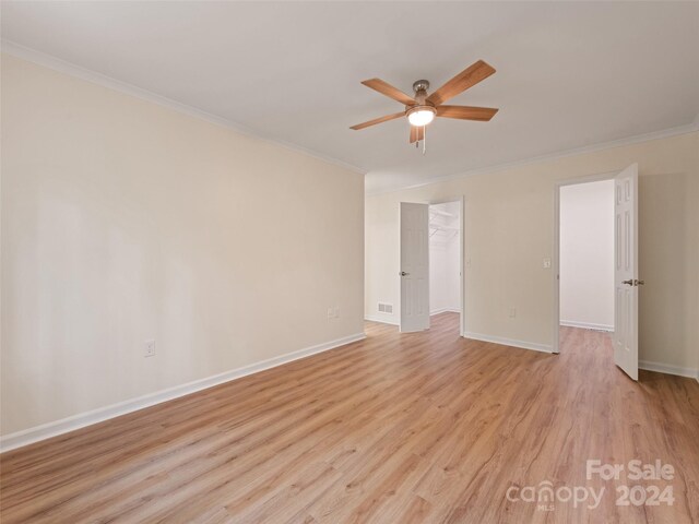 empty room with ceiling fan, light wood-type flooring, and crown molding