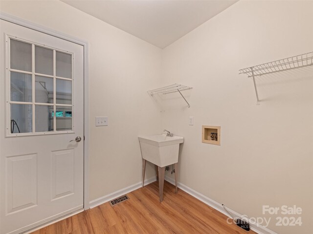 washroom featuring hookup for a washing machine and light wood-type flooring