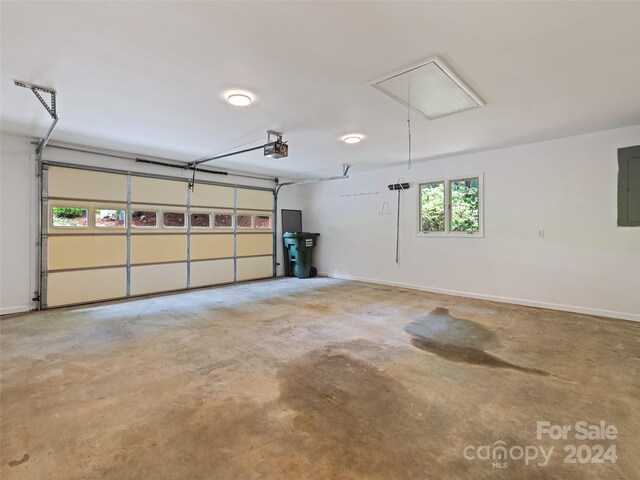 garage with electric panel and a garage door opener