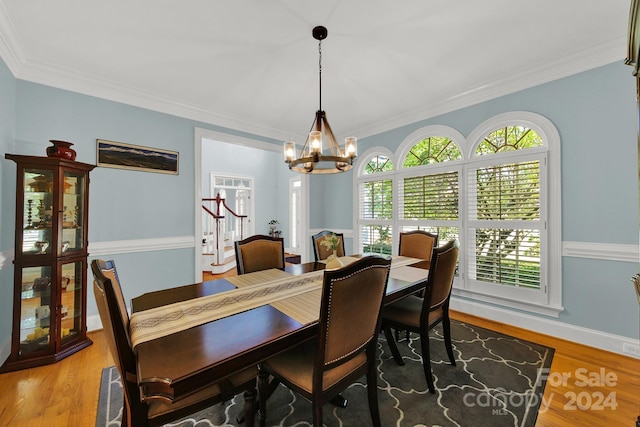 dining room with a chandelier, ornamental molding, and wood-type flooring