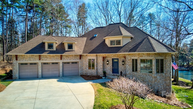 view of front facade with driveway, roof with shingles, and an attached garage