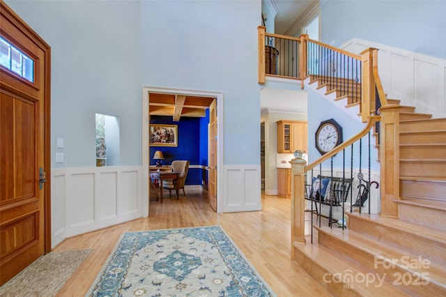 entryway featuring coffered ceiling, wood finished floors, and a decorative wall