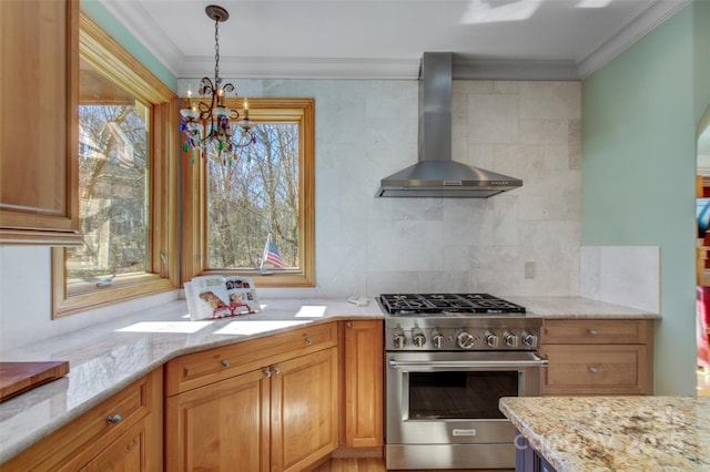 kitchen featuring light stone counters, stainless steel stove, crown molding, and wall chimney range hood