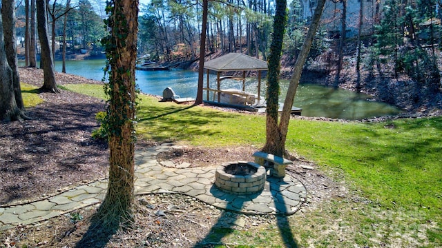 view of yard with a water view, a patio, and a fire pit