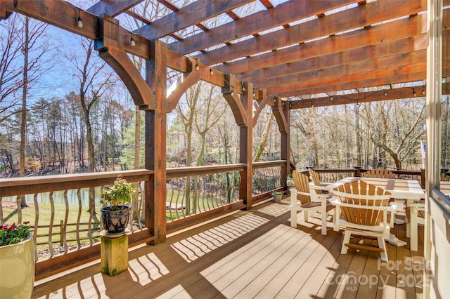 wooden deck featuring outdoor dining area and a pergola