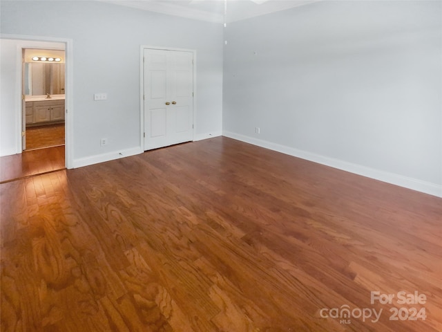 unfurnished bedroom with hardwood / wood-style floors and ensuite bath