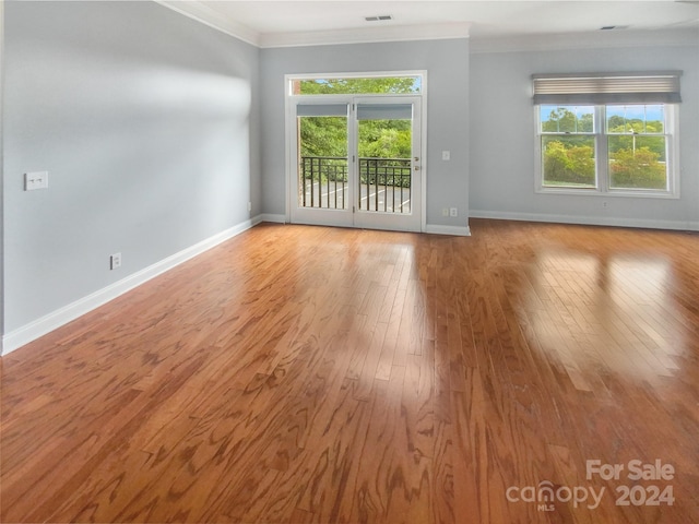 unfurnished room with crown molding, light hardwood / wood-style flooring, and a wealth of natural light