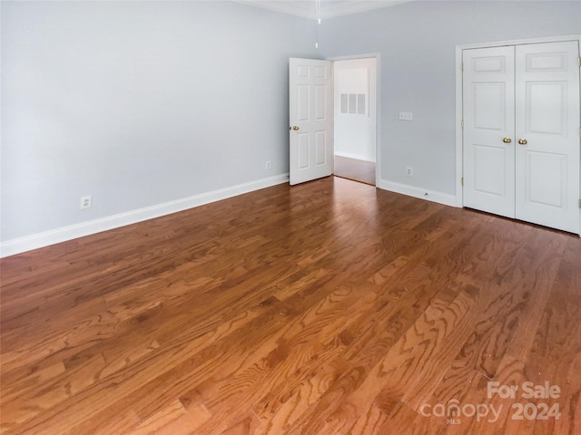 unfurnished bedroom featuring wood-type flooring and a closet