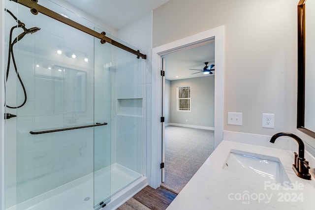 bathroom featuring wood-type flooring, sink, an enclosed shower, and ceiling fan