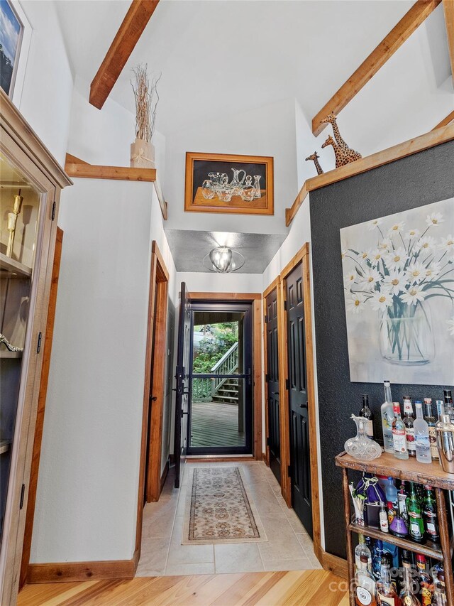 foyer with beamed ceiling and light hardwood / wood-style flooring