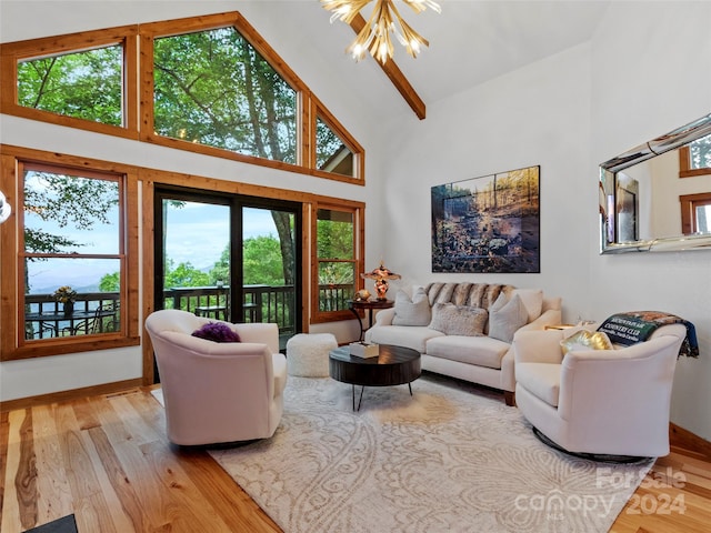 living room with light hardwood / wood-style flooring, a chandelier, and high vaulted ceiling