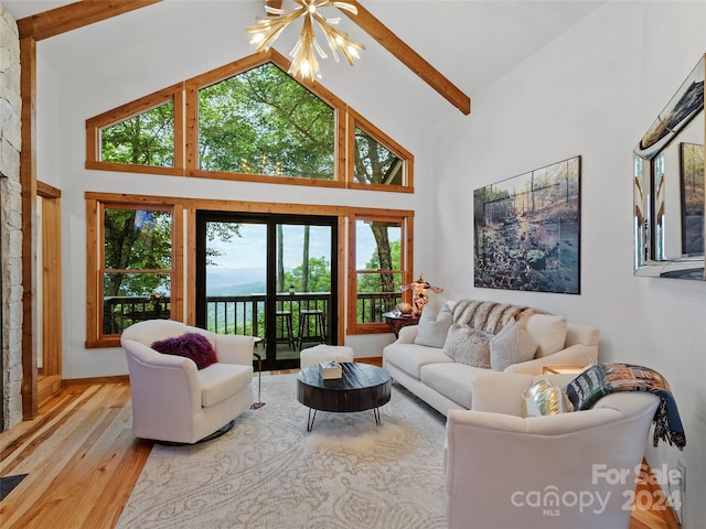 living room with high vaulted ceiling, plenty of natural light, beamed ceiling, and light hardwood / wood-style floors