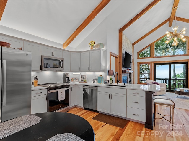 kitchen with stainless steel appliances, high vaulted ceiling, sink, light hardwood / wood-style flooring, and beamed ceiling