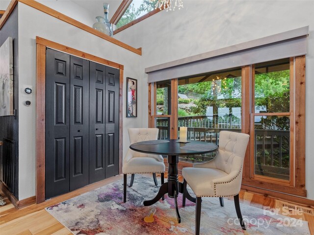 dining area featuring light wood-type flooring and vaulted ceiling