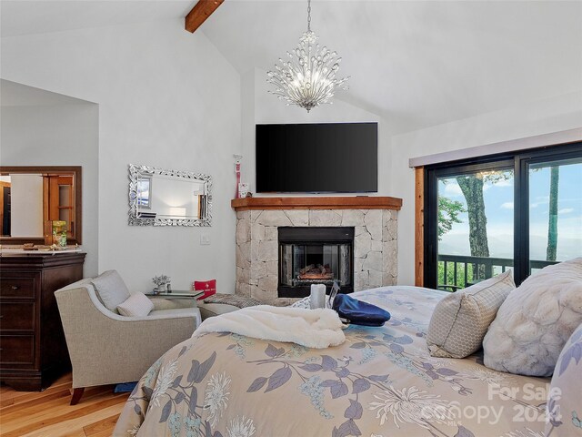 bedroom featuring light wood-type flooring, a fireplace, a chandelier, lofted ceiling with beams, and access to exterior