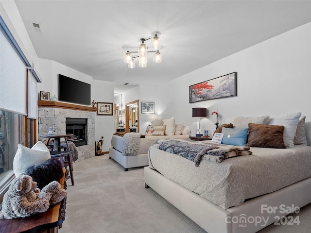 bedroom featuring a stone fireplace, visible vents, a notable chandelier, and light carpet