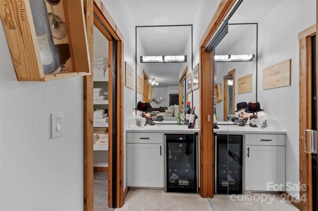 bathroom featuring wine cooler, vanity, and tile patterned flooring