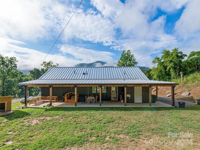 rear view of property featuring a yard and a patio area