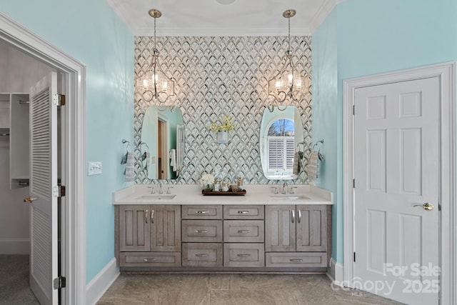 bathroom with crown molding, vanity, and a notable chandelier