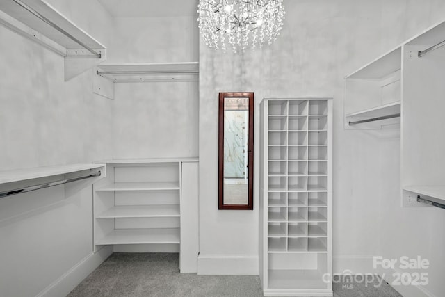 spacious closet featuring carpet flooring and a notable chandelier