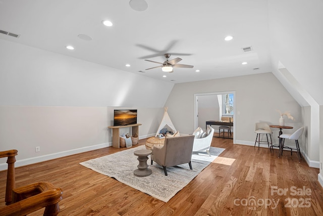 living room with ceiling fan, vaulted ceiling, and light hardwood / wood-style flooring