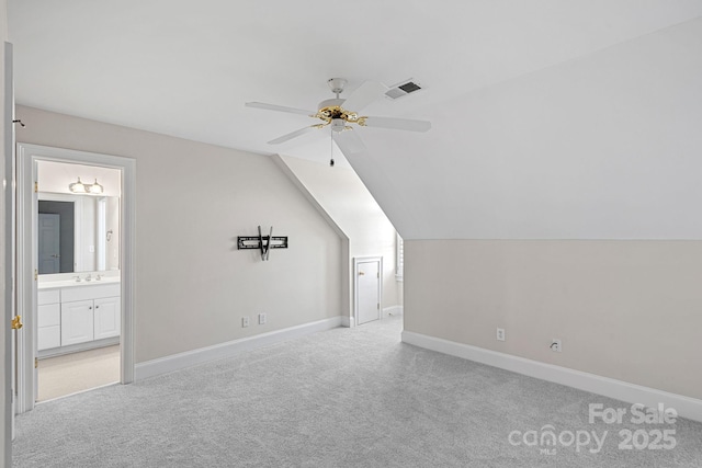 additional living space featuring sink, vaulted ceiling, light colored carpet, and ceiling fan