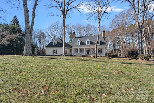 cape cod house featuring a front lawn